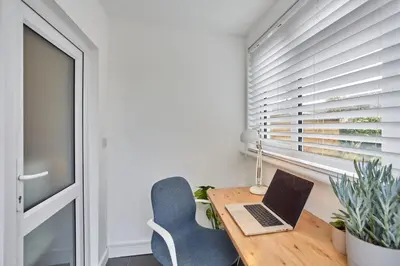 a desk with a laptop and a chair next to a window at Howlyek, in St Agnes Village in St. Agnes