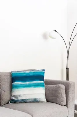 a blue and white pillow sitting on a couch at 2 Chatsworth Riverscape Apartments - Peaceful apartment in great location with free parking overlooking the Gannel just a short walk from Newquays incredible beaches and local amenities in Newquay