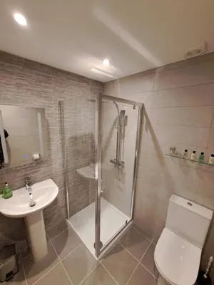 a bathroom with a shower and a toilet and a sink at 2 Chatsworth Riverscape Apartments - Peaceful apartment in great location with free parking overlooking the Gannel just a short walk from Newquays incredible beaches and local amenities in Newquay