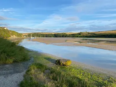 a body of water with a rock on the shore at 2 Chatsworth Riverscape Apartments - Peaceful apartment in great location with free parking overlooking the Gannel just a short walk from Newquays incredible beaches and local amenities in Newquay