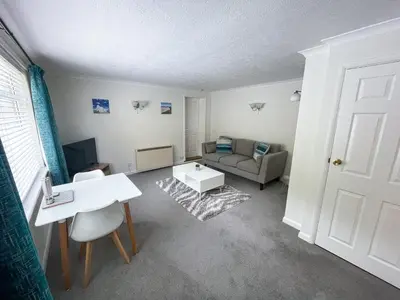 a living room with a couch and a table at 2 Chatsworth Riverscape Apartments - Peaceful apartment in great location with free parking overlooking the Gannel just a short walk from Newquays incredible beaches and local amenities in Newquay