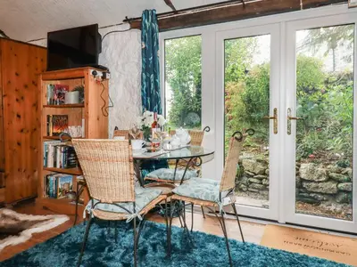 a dining room with a table and chairs and a window at Carminow Barn in Bodmin