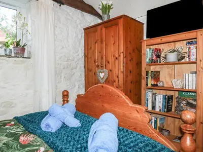 two stuffed teddy bears sitting on a bed at Carminow Barn in Bodmin