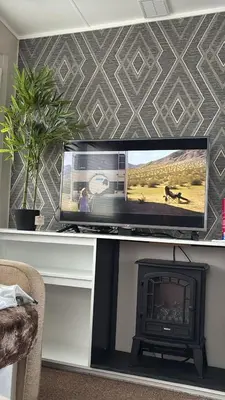 a living room with a television and a fireplace at Oakley Newquay Bay Resorts in Porth