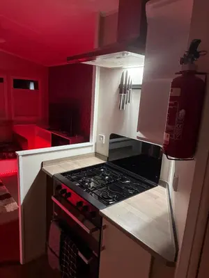 a kitchen with a stove and a red ceiling at Oakley Newquay Bay Resorts in Porth