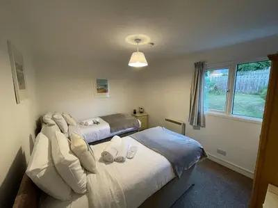 a bedroom with two beds and a window at Sea Spirit - Sweeping Sea Views first floor spacious modern apartment in Looe- with FREE parking! in Looe