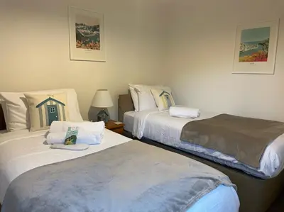 a bedroom with two beds and a lamp on a table at Sea Spirit - Sweeping Sea Views first floor spacious modern apartment in Looe- with FREE parking! in Looe