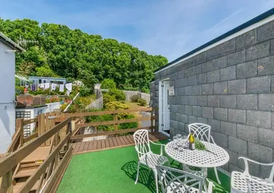 a patio with a table and chairs on a deck at Sea Spirit - Sweeping Sea Views first floor spacious modern apartment in Looe- with FREE parking! in Looe