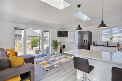 a kitchen and living room with a couch and a table at 2022 Stylish Flat in Central Hayle in Hayle