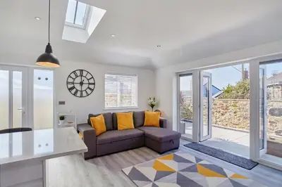 a living room with a couch and a table at 2022 Stylish Flat in Central Hayle in Hayle