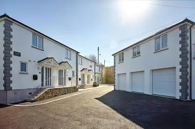 a row of white houses with garages at 2022 Stylish Flat in Central Hayle in Hayle