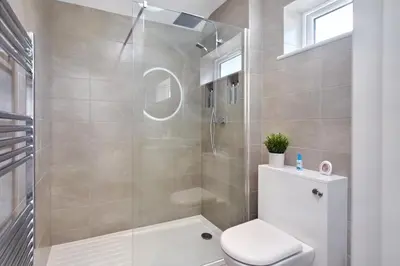 a bathroom with a toilet and a glass shower at 2022 Stylish Flat in Central Hayle in Hayle