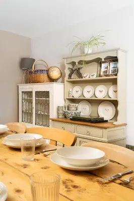 a dining room table with white plates on it at Daydreamer Cottage in Padstow