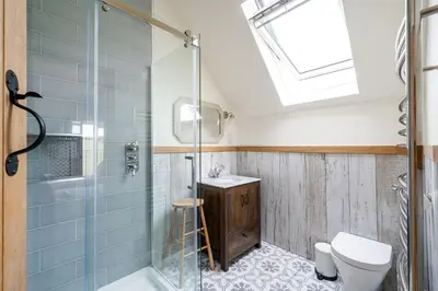 a bathroom with a shower and a toilet and a sink at Daydreamer Cottage in Padstow