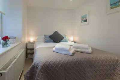 a bedroom with a large bed with two pillows at Ocean Gate in Carbis Bay