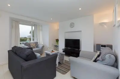 a living room with two couches and a television at Ocean Gate in Carbis Bay