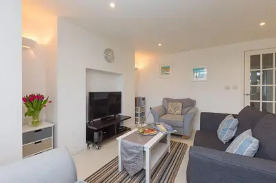 a living room with a couch and a tv at Ocean Gate in Carbis Bay