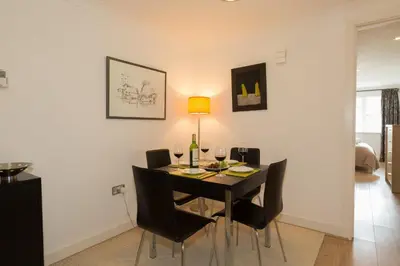 a dining room table with black chairs and a lamp at The Point in St Ives