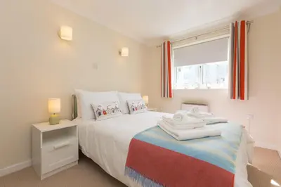 a bedroom with a bed with towels on it at Atlantic Blue in Carbis Bay