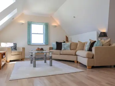 a living room with two couches and a table at Celeste in Carbis Bay