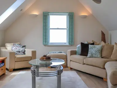 a living room with two couches and a table at Celeste in Carbis Bay