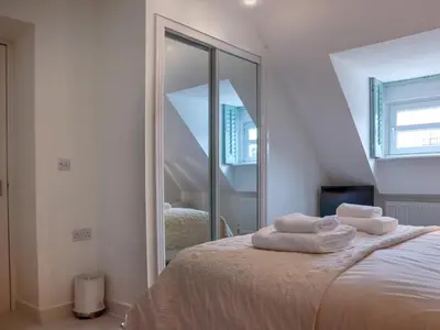 a bedroom with a mirror and a bed with towels at Celeste in Carbis Bay