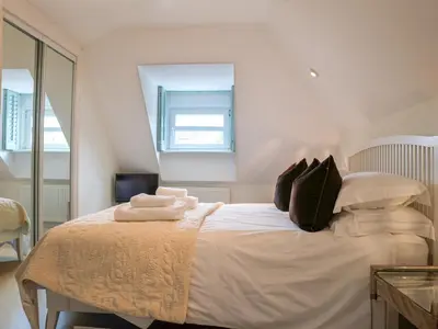 a bedroom with a bed with white sheets and pillows at Celeste in Carbis Bay