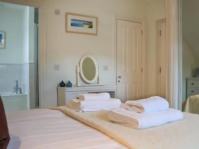 a bedroom with two towels on a bed with a mirror at Celeste in Carbis Bay