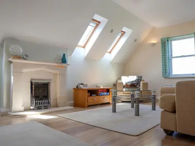 a living room with a fireplace and skylights at Celeste in Carbis Bay