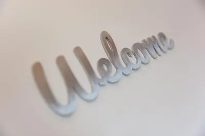 a close up of the word welcome spelled out in cursive handwriting at Hebaska in Carbis Bay