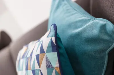 a blue pillow with a tie on a couch at Hebaska in Carbis Bay