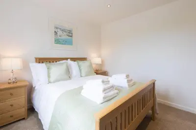 a bedroom with a bed with towels on it at Hebaska in Carbis Bay