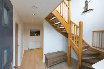 a wooden staircase in a home with white walls at Hebaska in Carbis Bay