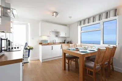 a kitchen and dining room with a table and chairs at St Ives Bay View in Carbis Bay