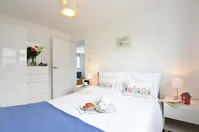a white bed with a plate of food on it at St Ives Bay View in Carbis Bay