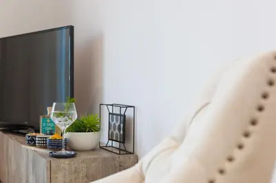 a living room with a tv and a glass of wine at Beach View in St Ives