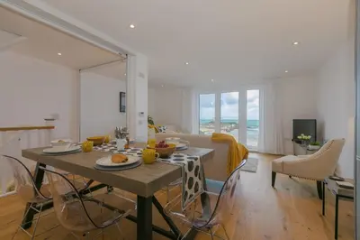 a dining room and living room with a table and chairs at Beach View in St Ives