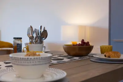 a table with plates and cups and a bowl of fruit at Beach View in St Ives