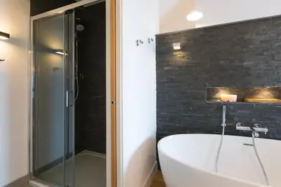 a bathroom with a tub and a glass shower at Beach View in St Ives