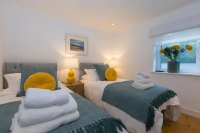 a bedroom with two beds with towels and a window at Beach View in St Ives
