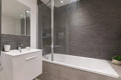 a bathroom with a shower and a tub and a sink at Beach View in St Ives