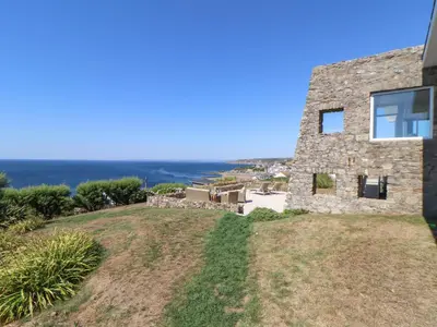 a stone house with a view of the ocean at Boscregan in Helston