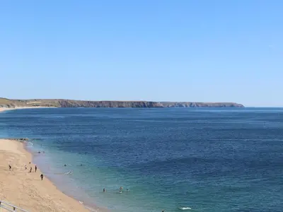 a group of people in the water at a beach at Boscregan in Helston