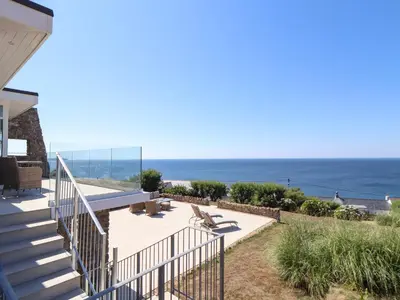a house with stairs and a view of the ocean at Boscregan in Helston