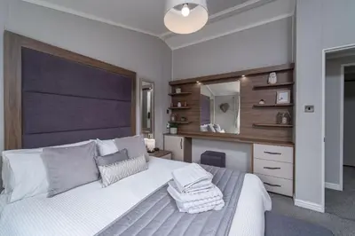 a bedroom with a white bed and a mirror at Number Four - Piran View in Padstow