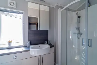 a white bathroom with a sink and a shower at Number Four - Piran View in Padstow