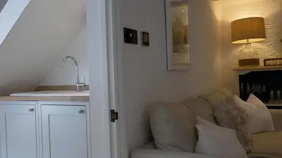 a living room with a couch and a sink at Padstow Escapes - Captains Cottage in Padstow