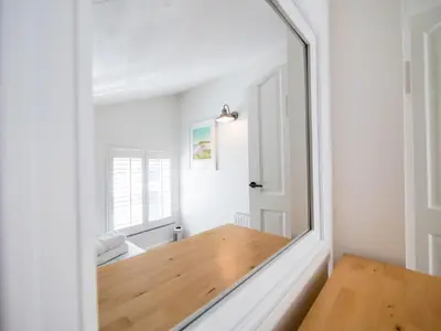 a mirror in a room with a wooden table at Padstow Escapes - Captains Cottage in Padstow