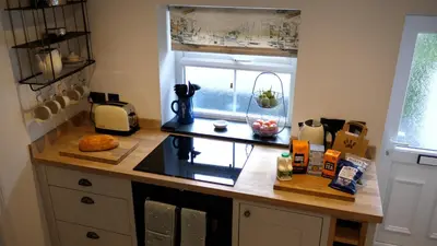a kitchen with a counter top with a window at Padstow Escapes - Captains Cottage in Padstow