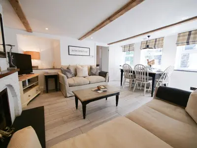 a living room with a couch and a table at Padstow Escapes - Captains Cottage in Padstow